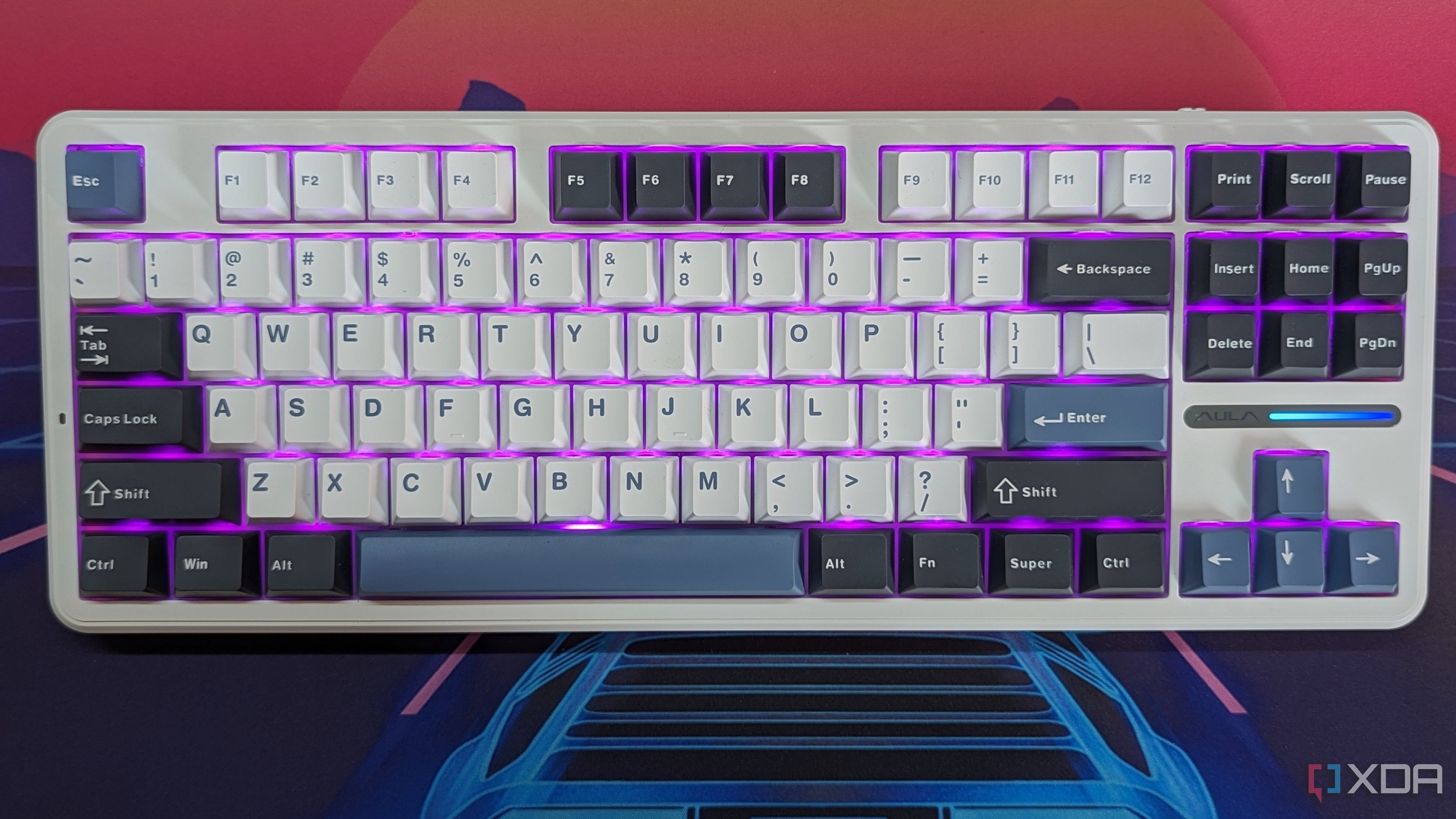 A keyboard shown from the top with violet RGB lighting 