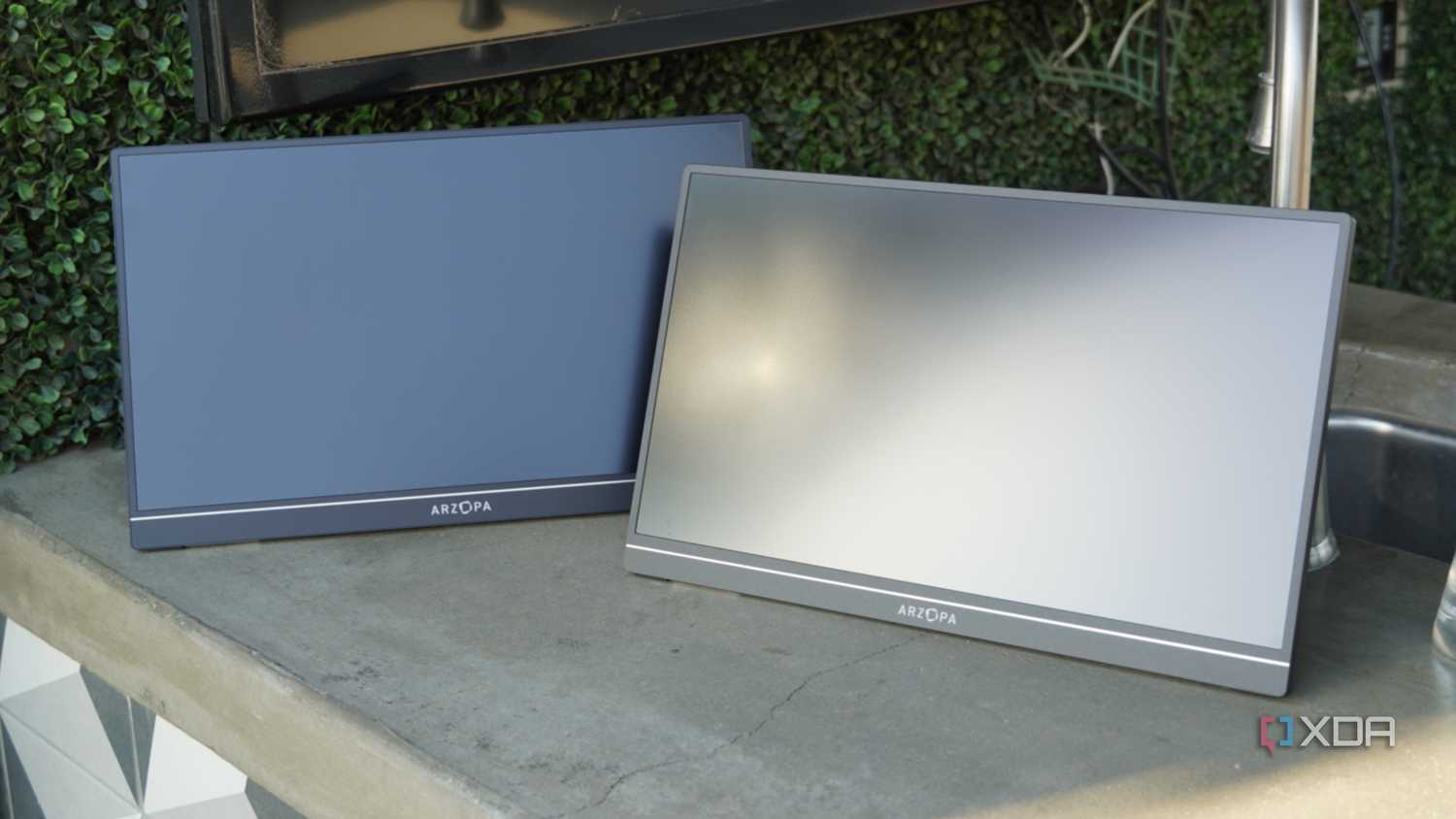 Two Arzopa portable monitors on a concrete countertop.