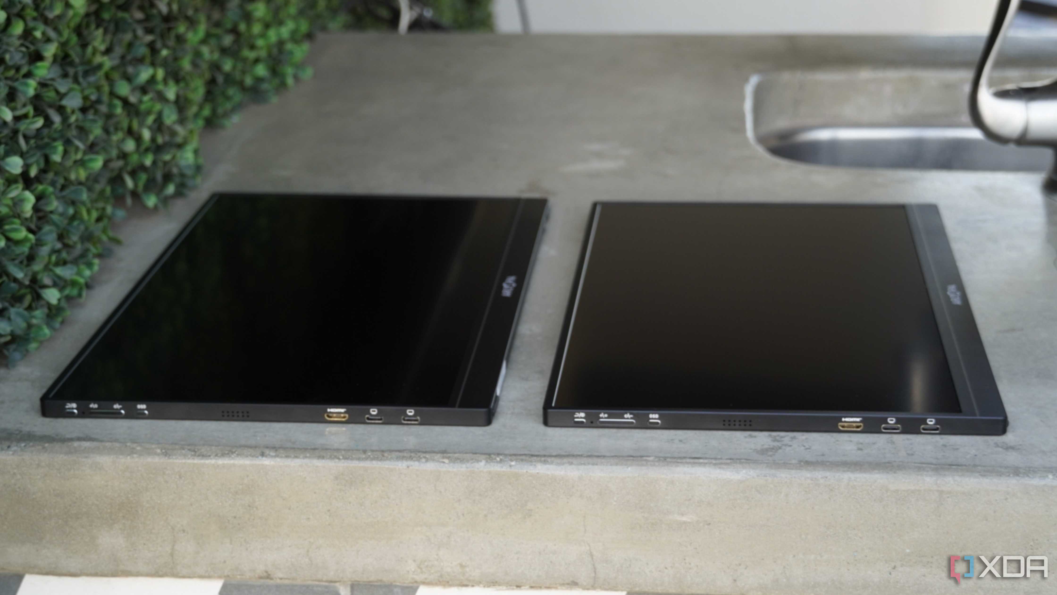 Two Arzopa portable monitors lying flat on a concrete countertop.
