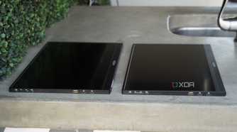 Two Arzopa portable monitors lying flat on a concrete countertop.