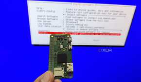 A person holding a Raspberry Pi Zero in front of the DietPi installation wizard
