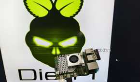 A person holding a Raspberry Pi 5 in front of a monitor displaying the DietPi LXDE desktop environment