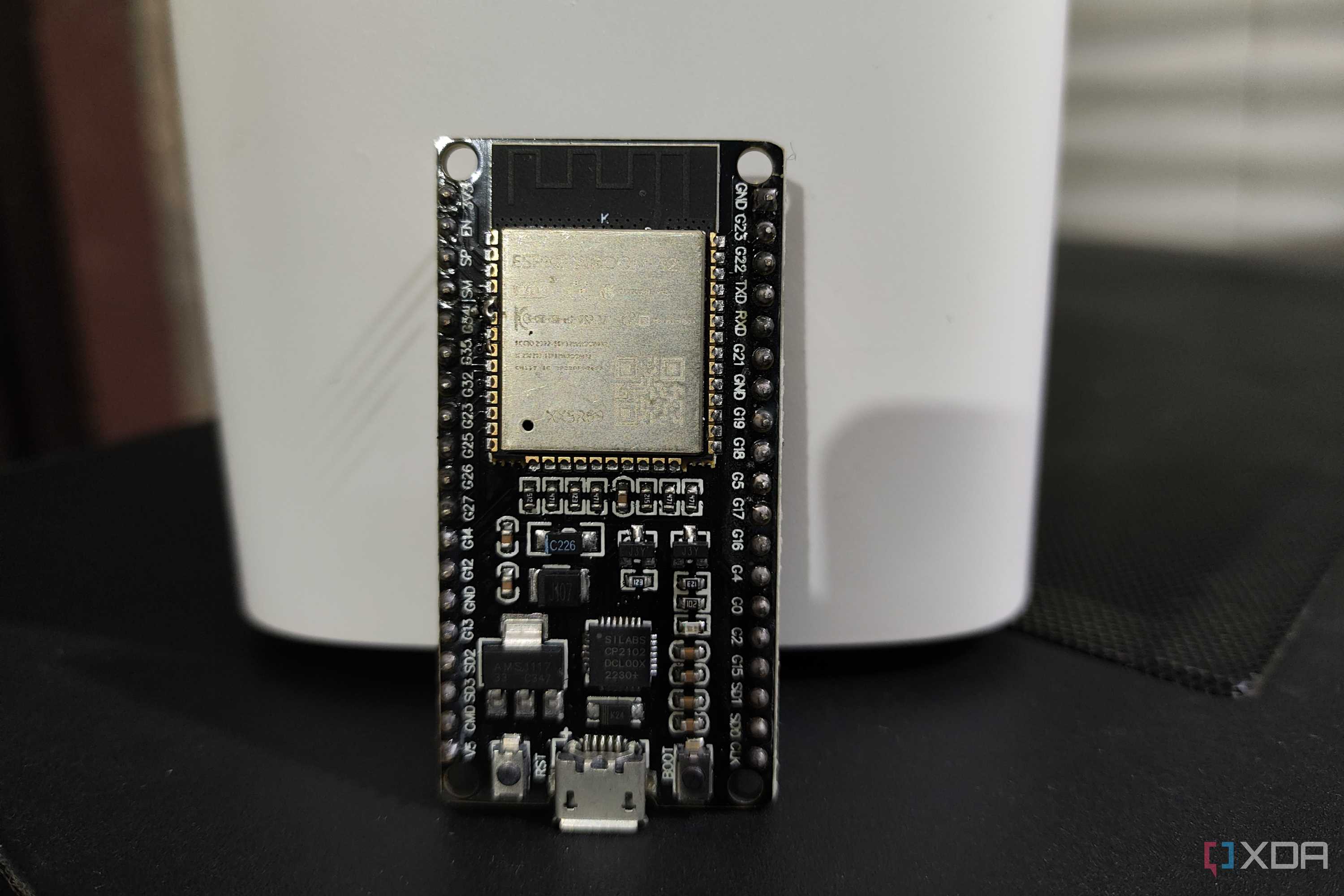An ESP32 resting against a D-Link mesh router