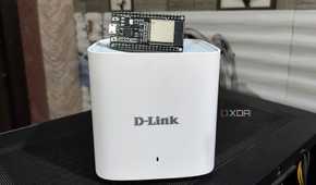 An ESP32 lying on top of a D-Link Eagle Pro mesh router