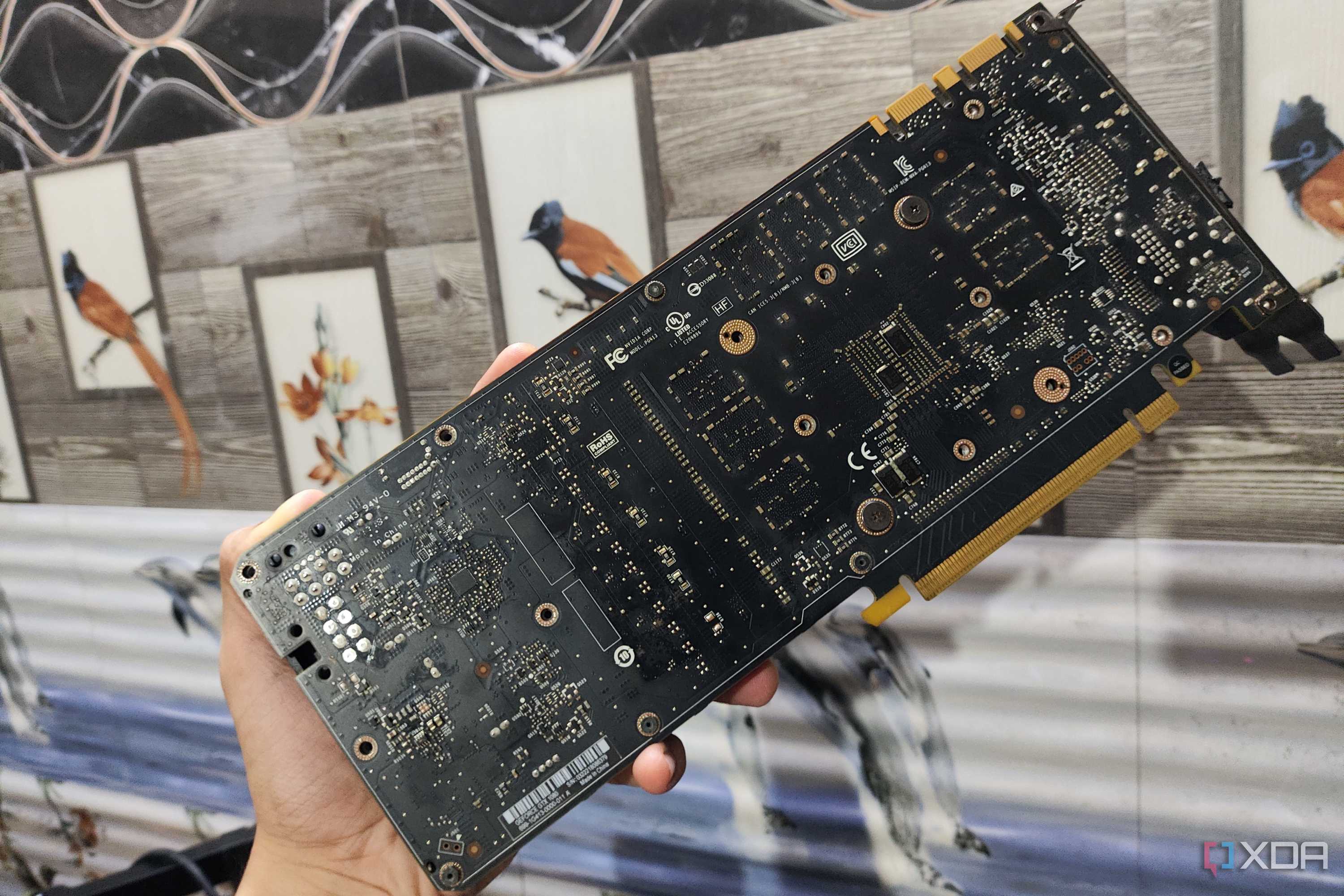 A person holding a GTX 1080 without its backplate
