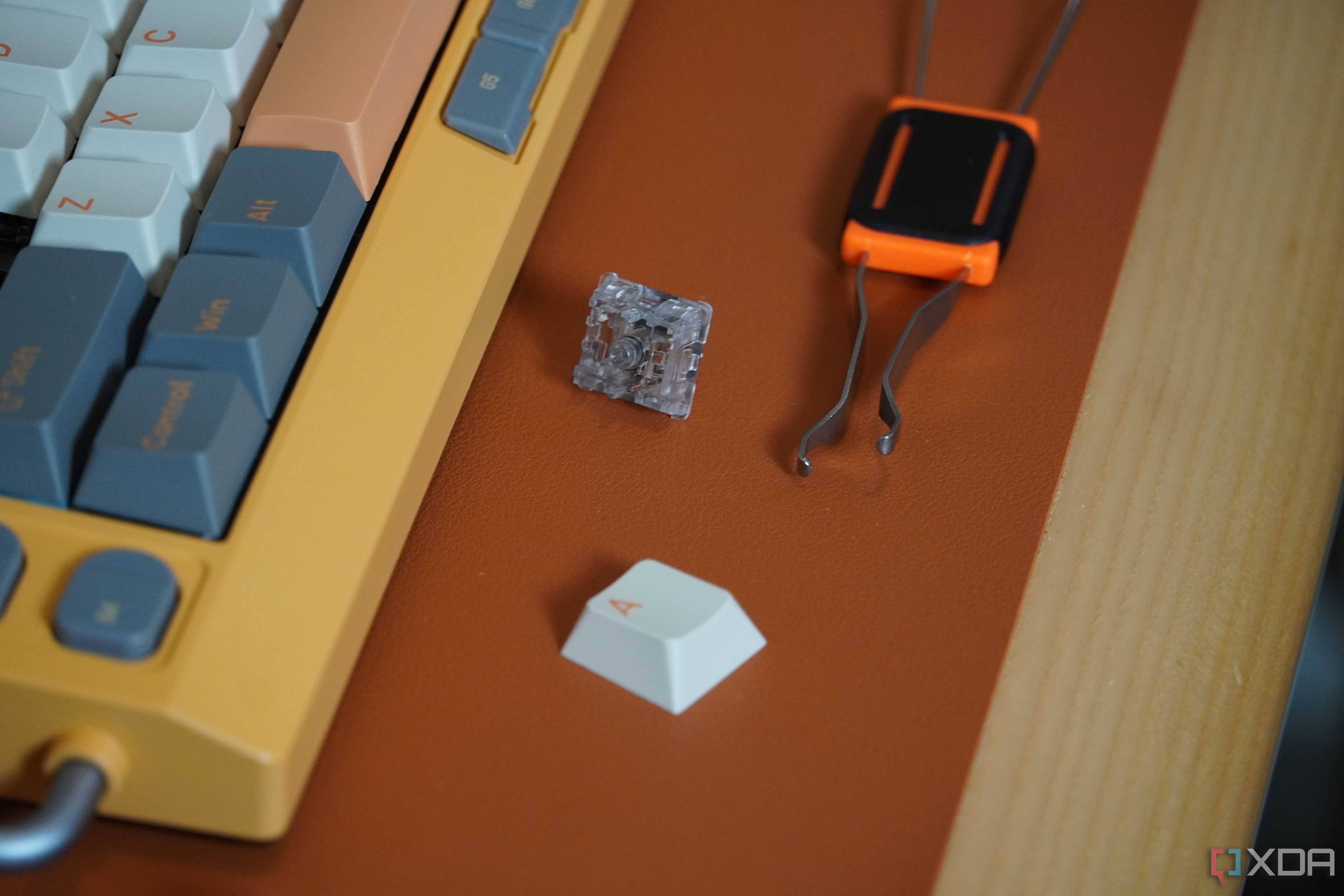 A keycap/switch puller beside the NuPhy Field75 keyboard.