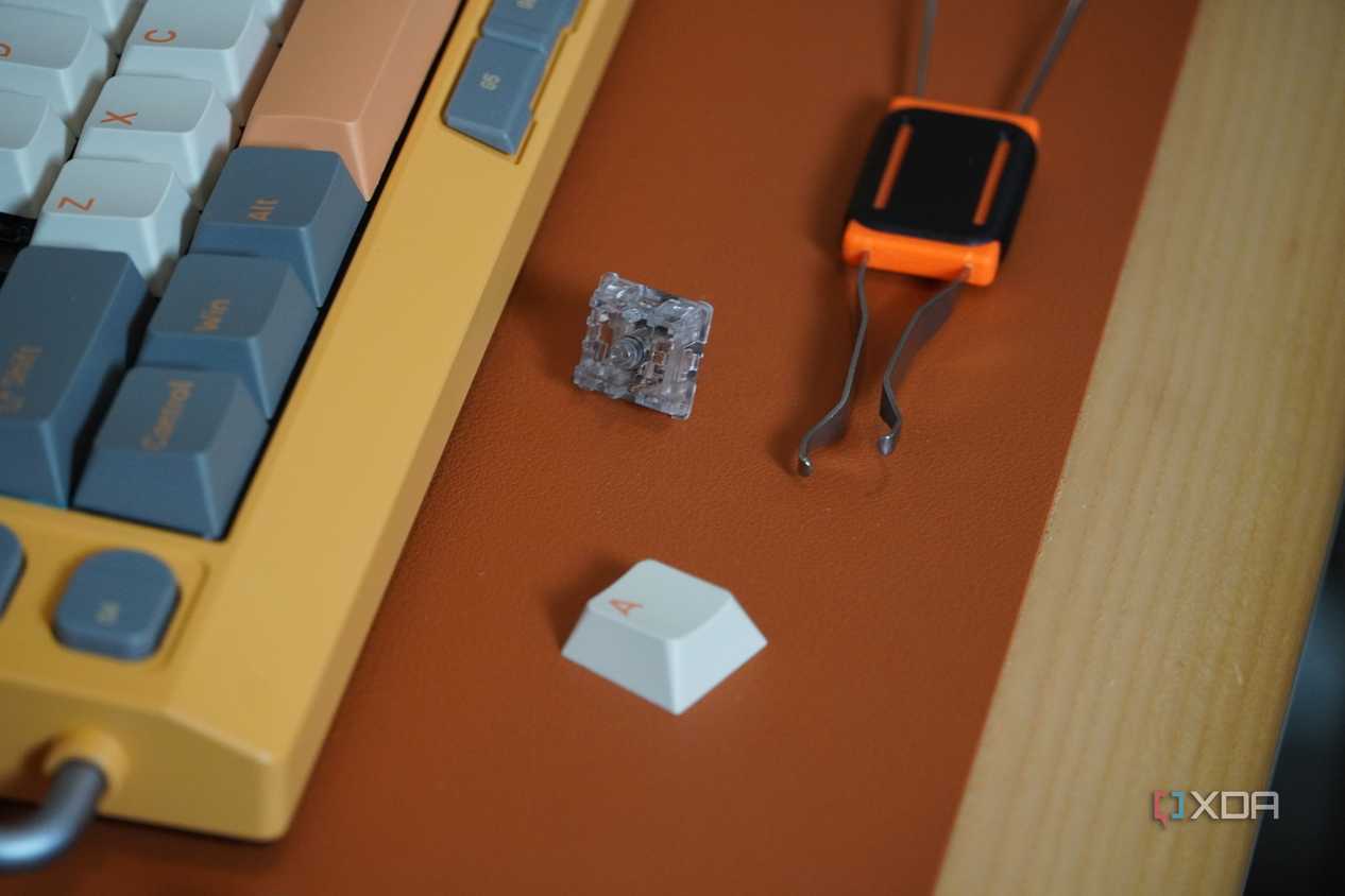 A keycap/switch puller beside the NuPhy Field75 keyboard.