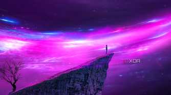 A wallpaper showing a person standing on the edge of a cliff looking at a purple universe