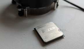 Ryzen 5 1600 processor next to stock cooler on a white surface