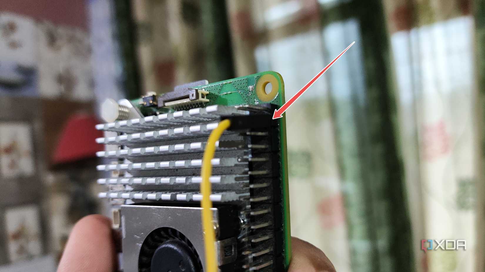 A jumper cable plugged into the +5V pin of a Raspberry Pi 5