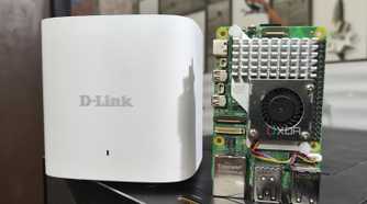 A Raspberry Pi 5 placed next to a D-Link Eagle Pro mesh router