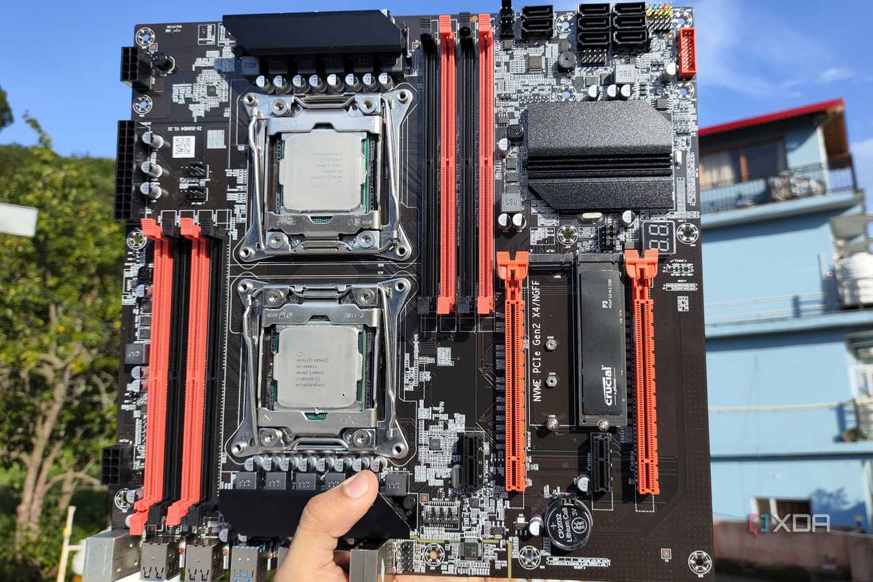 A person holding an X99 server motherboard with two Intel Xeon CPUs slotted in