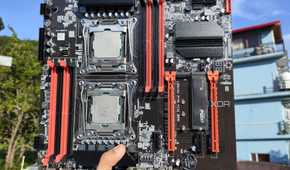 A person holding an X99 server motherboard with two Intel Xeon CPUs slotted in