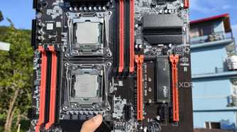 A person holding an X99 server motherboard with two Intel Xeon CPUs slotted in