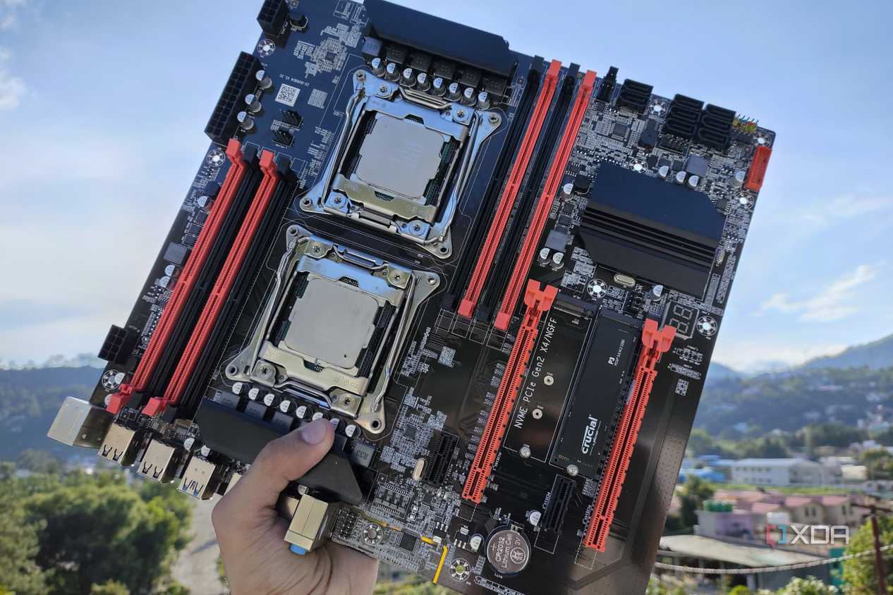 A person holding an X99 server motherboard with two Intel Xeon CPUs slotted in
