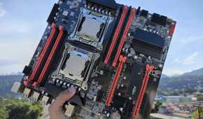 A person holding an X99 server motherboard with two Intel Xeon CPUs slotted in