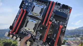 A person holding an X99 server motherboard with two Intel Xeon CPUs slotted in
