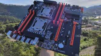 A person holding an X99 server motherboard with two Intel Xeon CPUs slotted in
