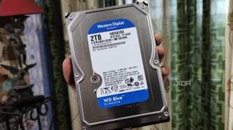 A person holding a WD Blue HDD