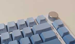 Close-up of a blue-white keyboard showing a metal knob