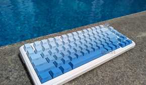 A blue-white keyboard near on a hard surface near a swimming pool