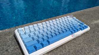 A blue-white keyboard near on a hard surface near a swimming pool
