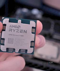 Hand holding an AMD Ryzen 7 7700 and Intel CPU