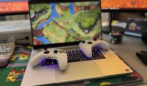 two xbox controllers laid on a razer blade 18 laptop playing cuphead