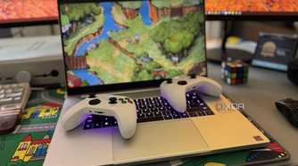 two xbox controllers laid on a razer blade 18 laptop playing cuphead