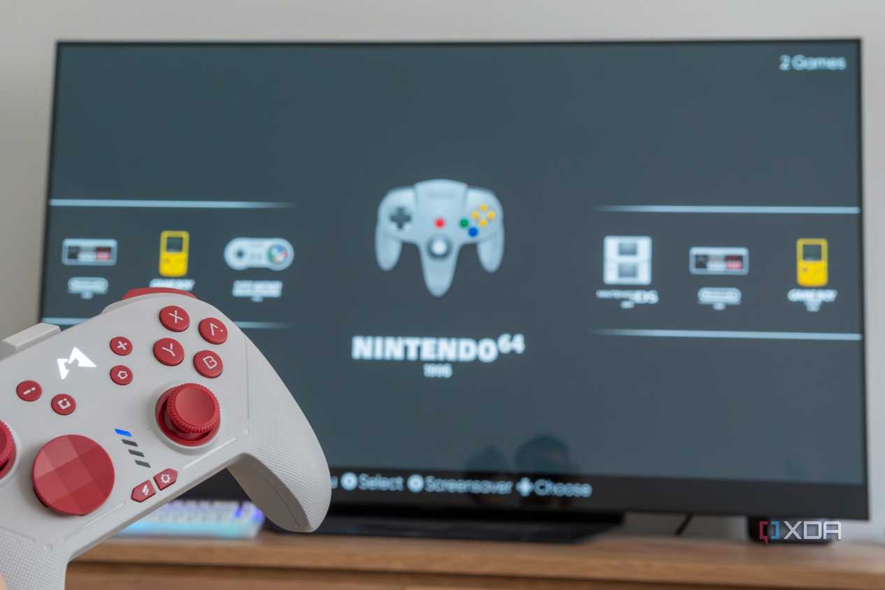 A console controller with a TV displaying the EmulationStation home screen in the background