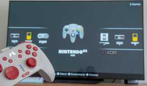 A console controller with a TV displaying the EmulationStation home screen in the background