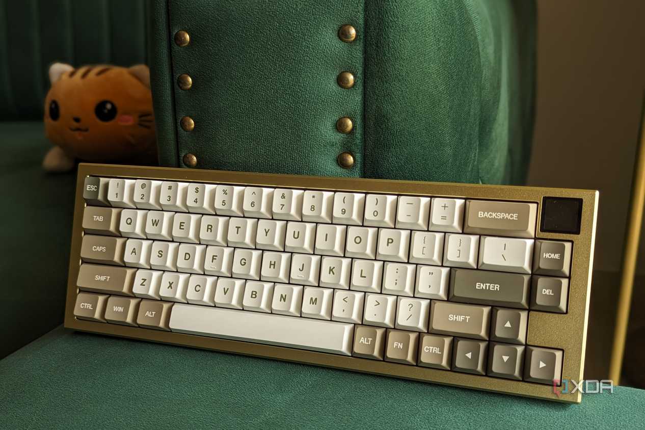 Front view of a gold and white mechanical keyboard on a green surface