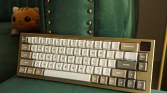 Front view of a gold and white mechanical keyboard on a green surface