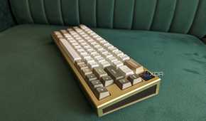 A gold and white mechanical keyboard on a green surface