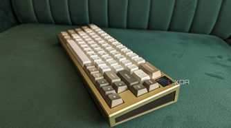 A gold and white mechanical keyboard on a green surface