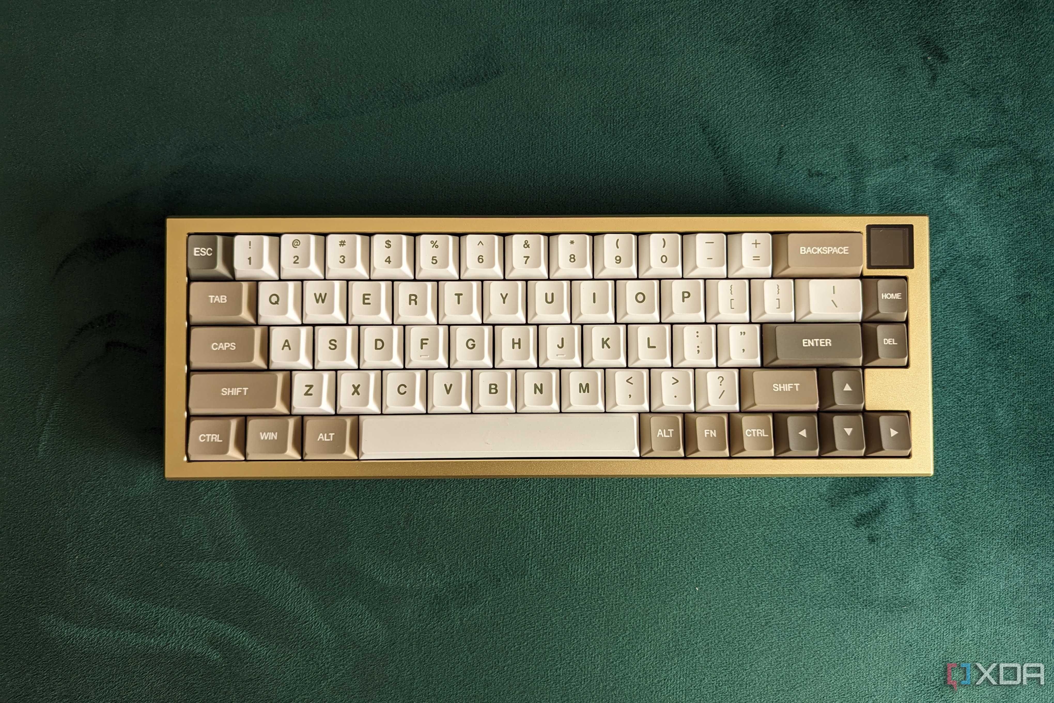 Top view of a gold and white mechanical keyboard on a green surface