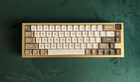 Top view of a gold and white mechanical keyboard on a green surface