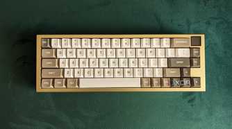 Top view of a gold and white mechanical keyboard on a green surface
