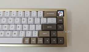 A gold and white mechanical keyboard showing a GIF on its LCS screen