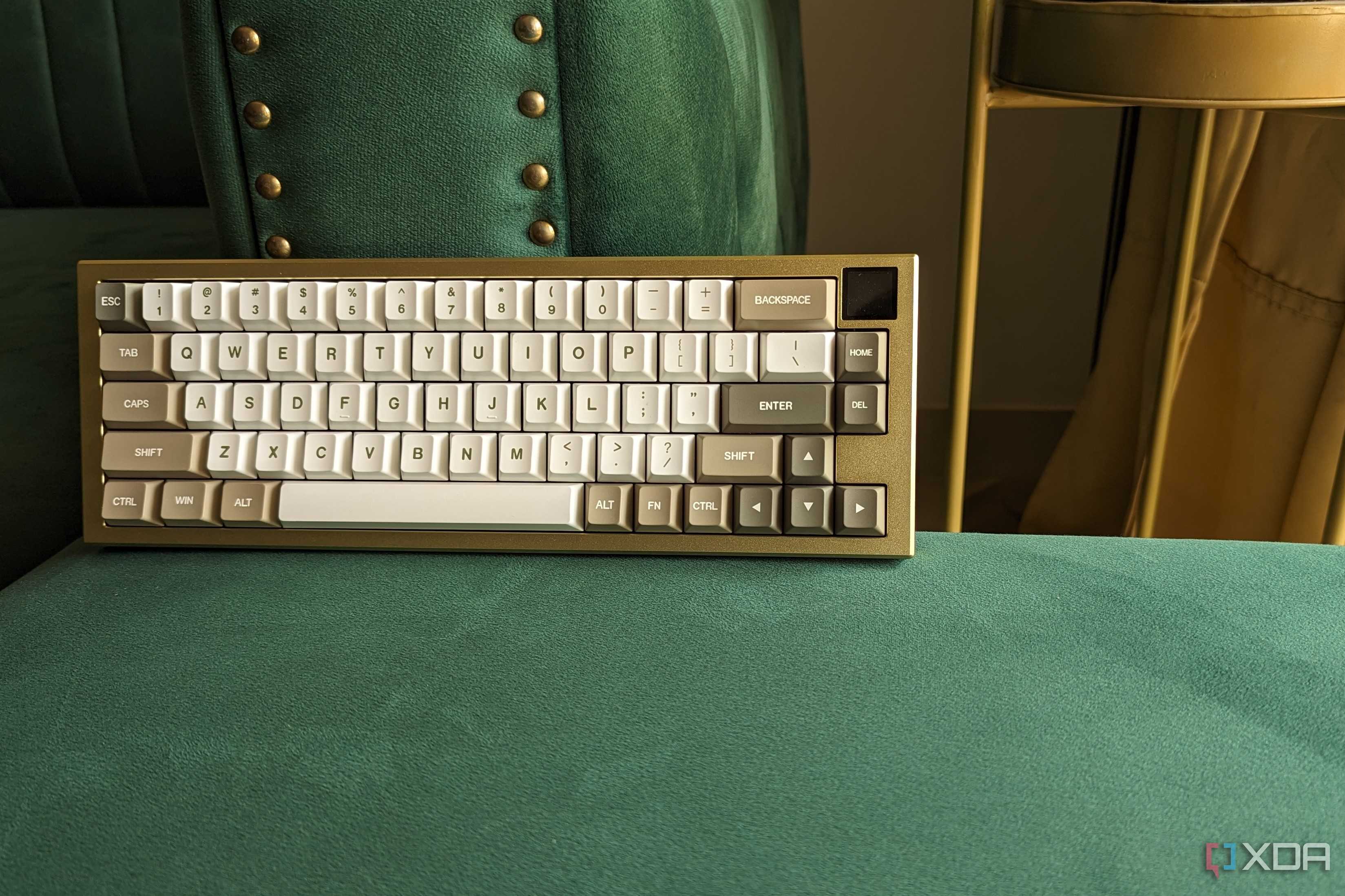 A gold and white keyboard with an LCD screen on a green surface