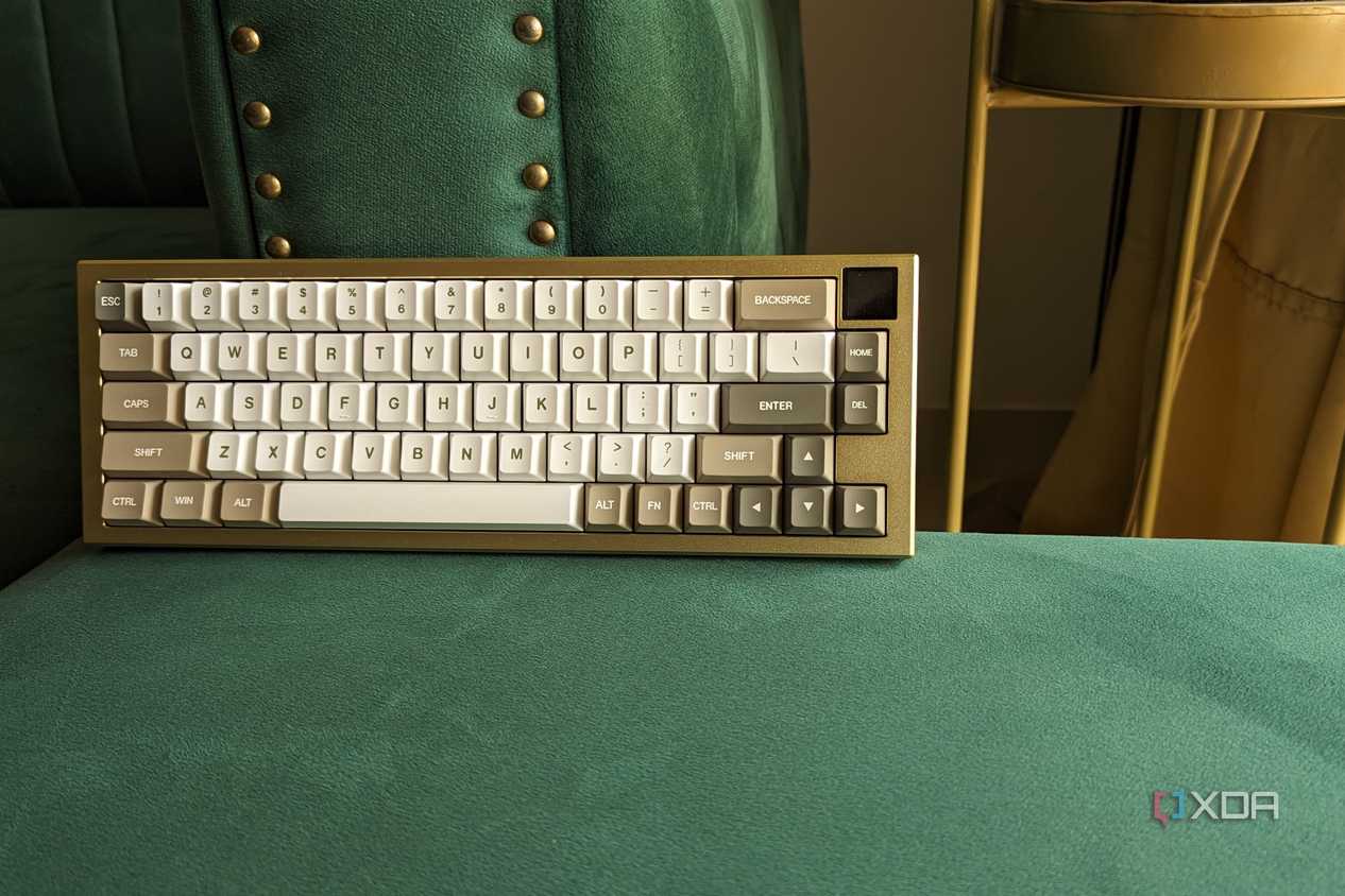 A gold and white keyboard with an LCD screen on a green surface