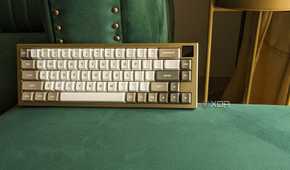A gold and white keyboard with an LCD screen on a green surface