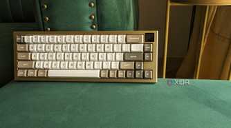 A gold and white keyboard with an LCD screen on a green surface
