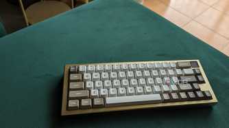 A gold and white keyboard on a green surface