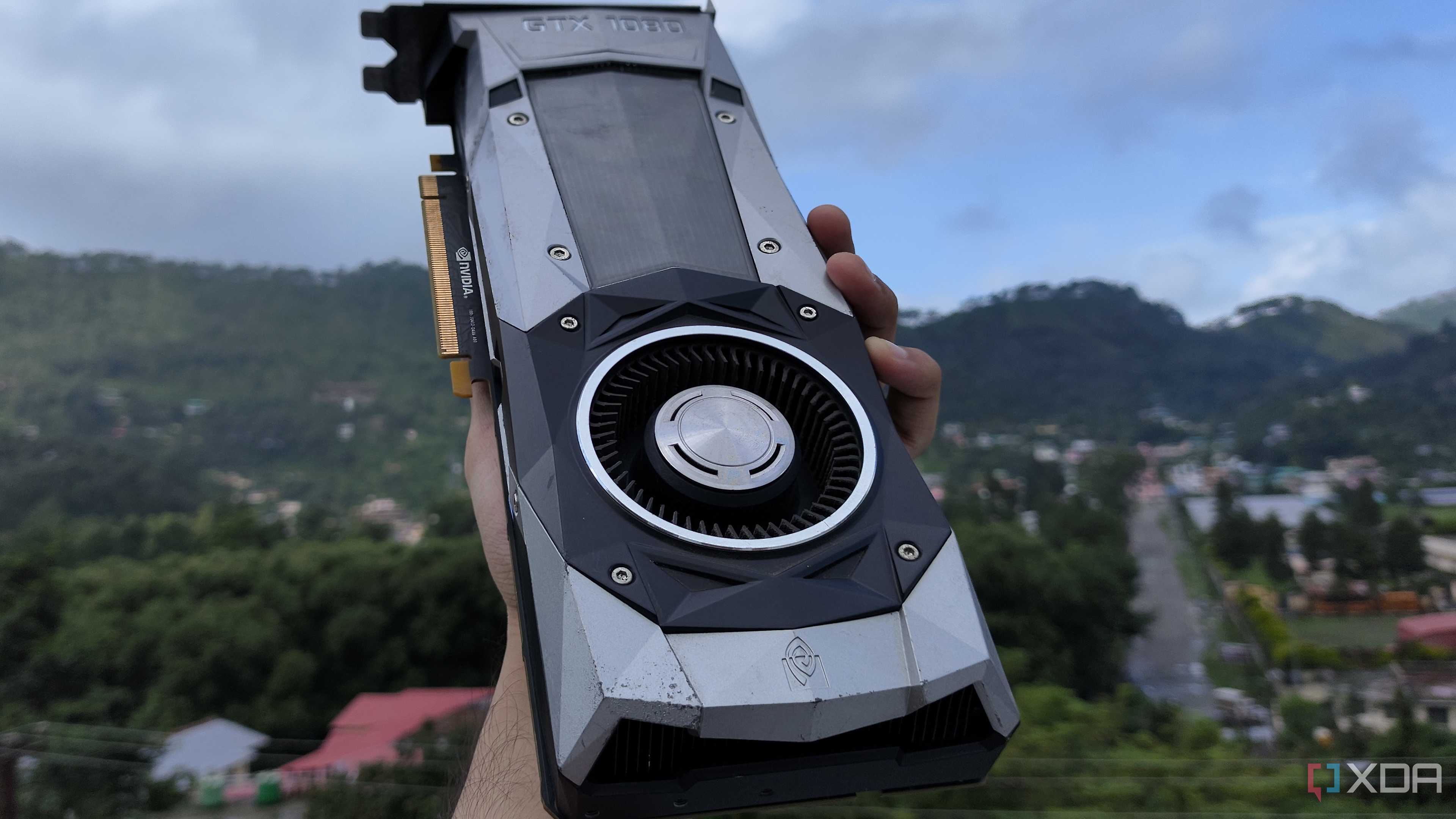 A person holding a GTX 1080 Founders Edition GPU