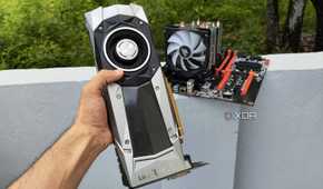 A person holding a GTX 1080 Founders Edition GPU in front of a server PC