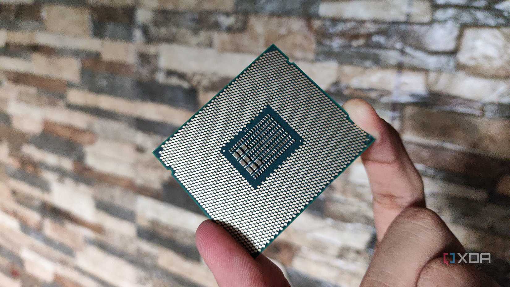 A person holding a server-grade Intel Xeon E5-2650 v4 processor