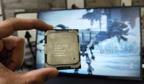 A person holding a server-grade Intel Xeon E5-2650 v4 processor in front of a monitor