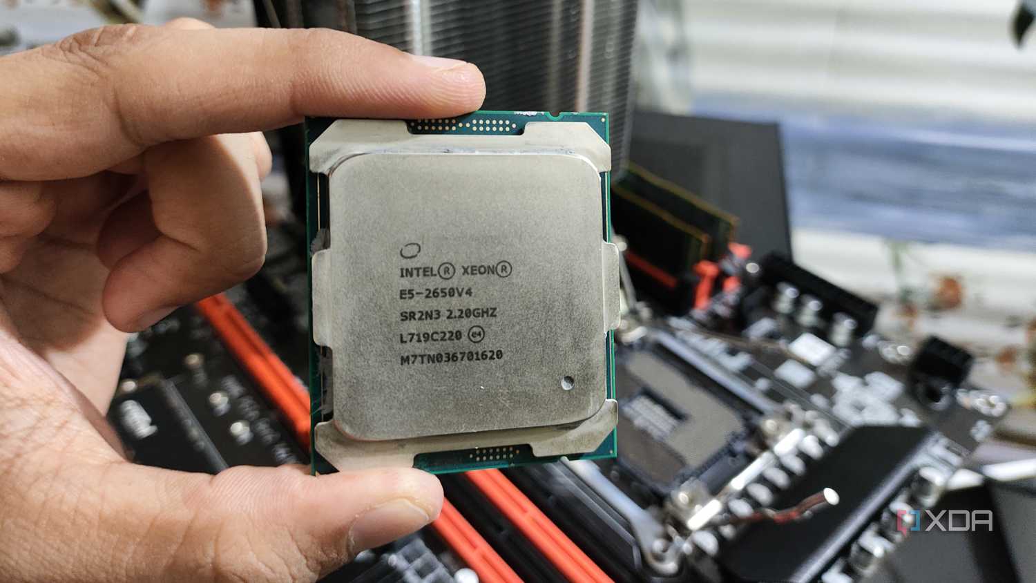 A person holding a server-grade Intel Xeon E5-2650 v4 processor