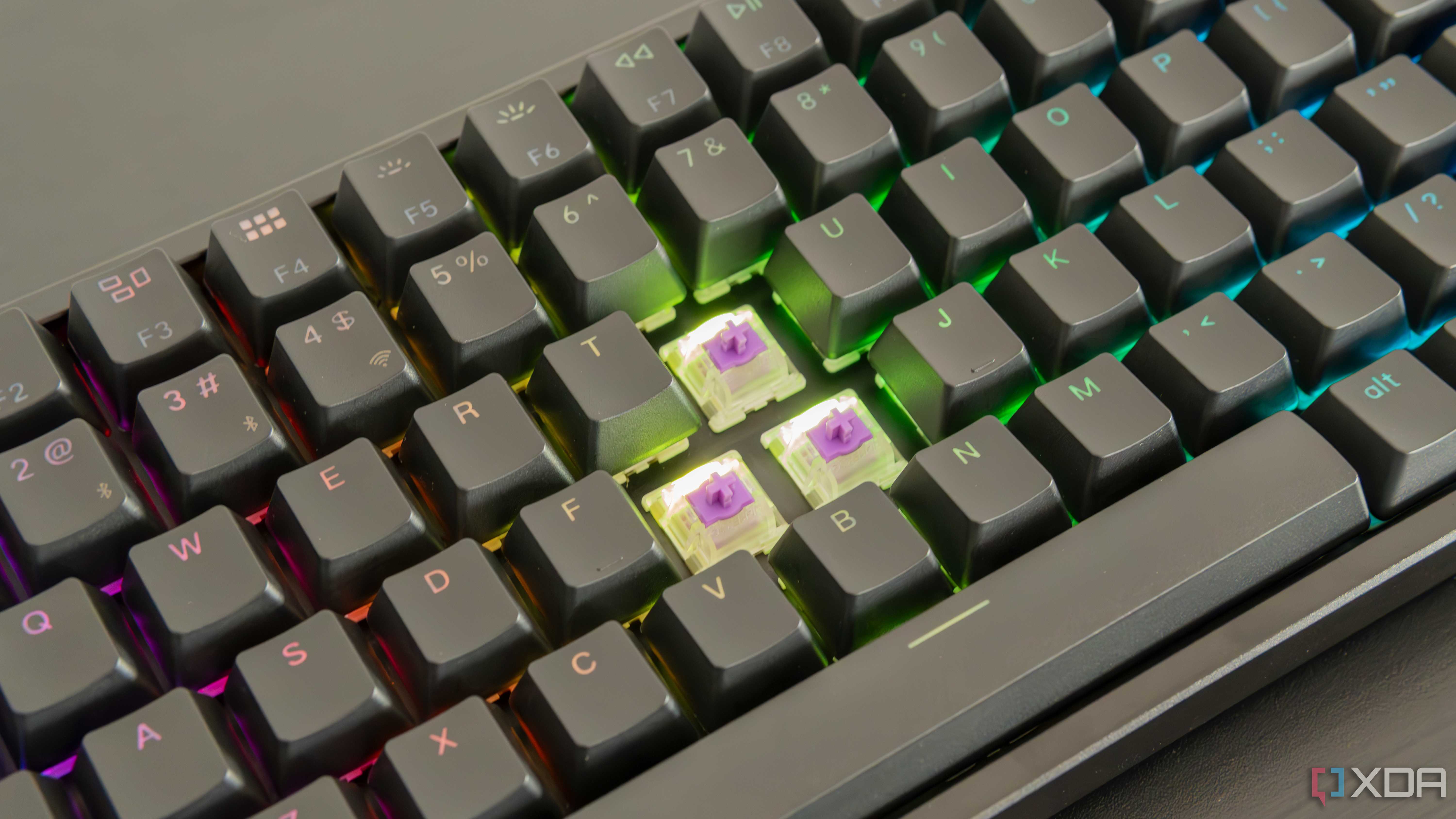 Close-up of the Keychron K2 HE with three keycaps removed, showing the switches underneath